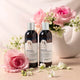 Two bottles of sensitive shampoo and conditioner with pink roses and flowers on a light background