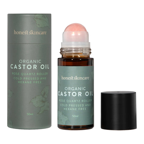 Honest Skincare Organic Castor Oil Rose Quartz Roller 50ml bottle with its roller ball showing, standing beside its grey cylinder box on white