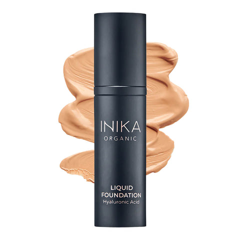 Bottle of INIKA Organic Liquid Foundation with a honey-coloured swatch behind it.