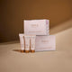 Inika Organic Skin Luminosity Trial pack stacked on top of each other with skincare items stood next to them on a beige background.