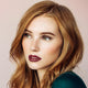 Young woman with fair, freckly skin tone & dark blonde hair wearing bordeaux rouge lipstick.