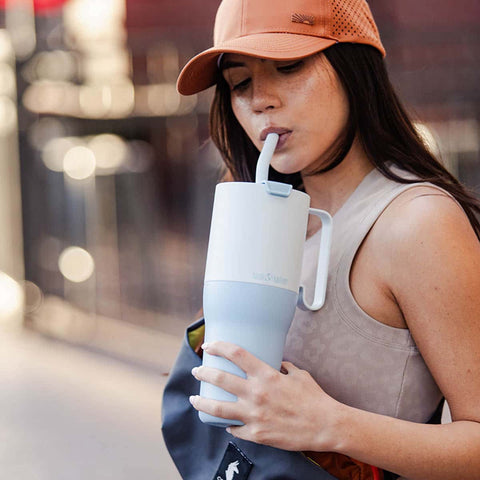 Athletic woman sipping from Klean Kanteen tumbler.