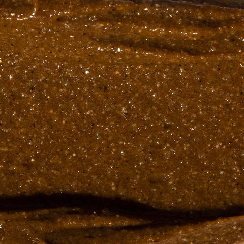 Swatch of glittering, textured amber & cocoa toned body scrub.