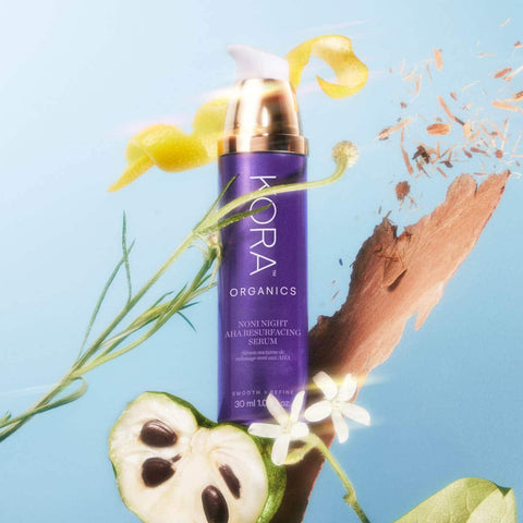 Kora Organics serum bottle with natural elements on a blue background.