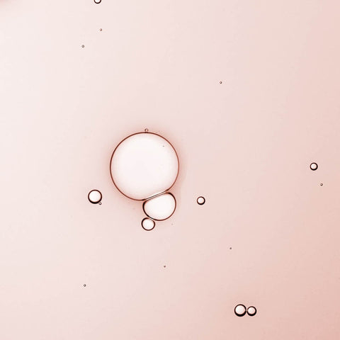 Swatch of serum - liquid texture, pinkish tint with a few bubbles.