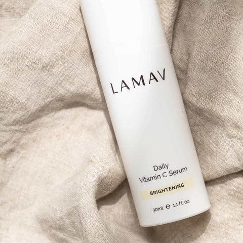 LAMAV Daily Vitamin C Serum bottle on a textured beige fabric background