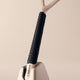 Close-up of a reusable razor with a black textured handle on a beige background