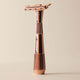 Rose gold safety razor on a beige background