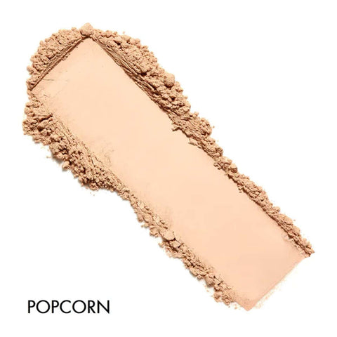 Cosmetic powder with a textured border labeled 'Popcorn' on a white background