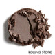 Brown pressed eyeshadow showing texture on a white background, labeled 'Rolling Stone'.