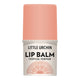 A lip balm tube on a plain white background. The cap is a soft peach-pink, and the lower container is white with black text.