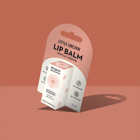 A package of Little Urchin Lip Balm, featuring a white and dusty pink cardboard blister pack with a single cube of balm visible, set against a solid terracotta background.