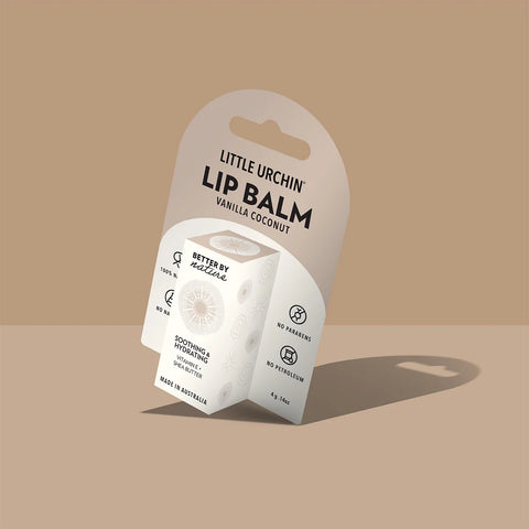 A small white lip balm package on a hanger card photographed against a warm beige background with a soft shadow.