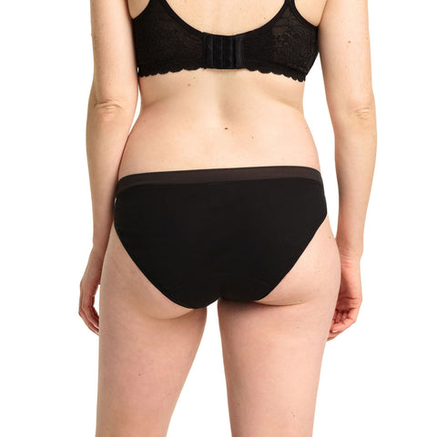 Person wearing a black bra and underwear set on a white background