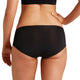 Person wearing black high-waisted underwear on a plain background