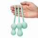 Hand holding 3 mint silicone kegel exercisers for strengthening the pelvic floor.