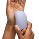 Hand holding a purple silicone air suction stimulator on a white background.