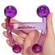 Purple body massager, held in a person's hand against a white background. 
