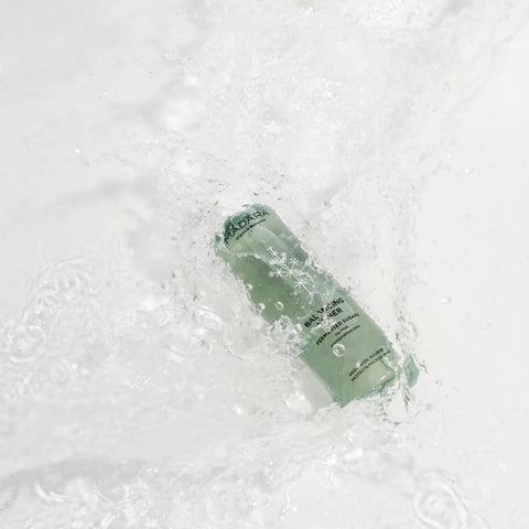 A green bottle dropping and splashing into water.