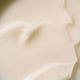 A close-up texture shot of a thick, creamy off-white cosmetic cream.