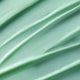 Close-up of light green serum with visible texture.