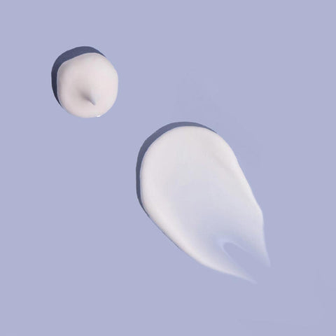 Two swatches of MooGoo eczema and psoriasis white cream on a light purple background