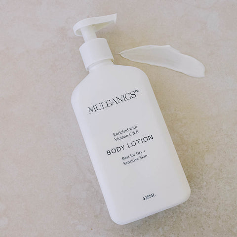 MUDGANICS body lotion bottle on a beige background next to a swatch.
