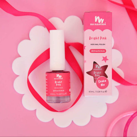 Nail Polish and packaging styled on a pink & white background with a pink ribbon.