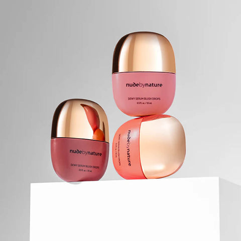 Three Nude By Nature blushes stacked on a white surface with a light grey background.