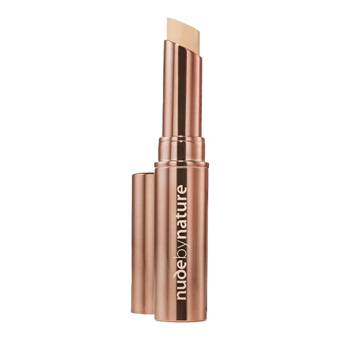 Stick concealer in a rose gold tube with Nude by Nature logo on it.