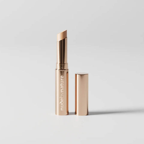 Stick concealer with Nude by Nature logo on a light grey background.