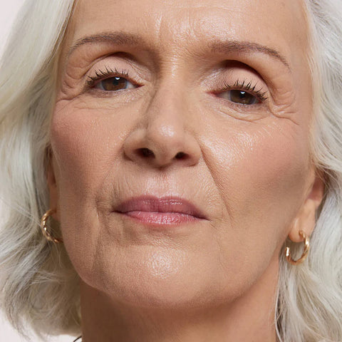 Close-up of a woman's face wearing Flawless Concealer in Rose Beige shade.