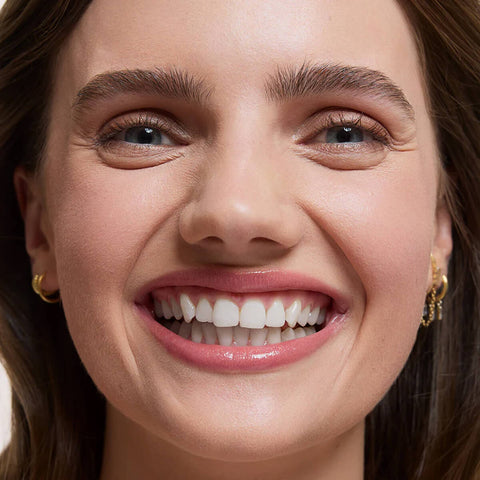 Close-up of a woman's face wearing Flawless Concealer in Shell Beige shade.