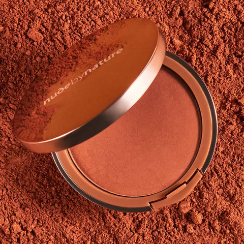 Compact Nude By Nature Pressed Matte Mineral Bronzer 10g on a red powder background.