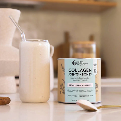 225g container Nutra Organics Collagen Joints + Bones next to a glass of milk.