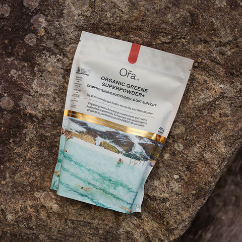 480g pouch Ora Organic Greens Superpowder+ placed on a rock, vegan supplement to support energy, gut health, immunity, and detox.