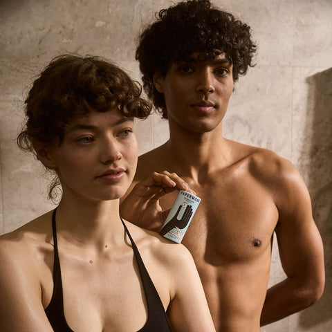 Two people standing close together, one holding a product labeled 'Papermoon Clean Deodorant - Aloe & Agave'.