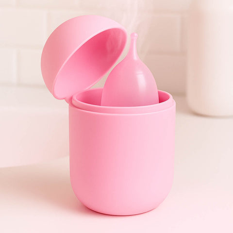 Pink silicone cup with a lid on a light pink background