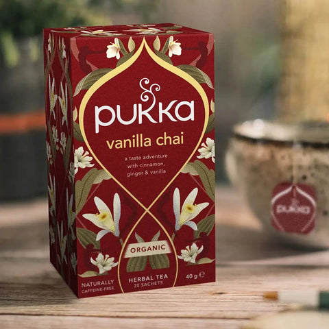 Pukka Vanilla Chai tea box on a wooden surface with a blurred background