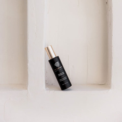 Black Retreatment Botanics Collagen Calm Activated Mist 100ml with gold cap on a white textured background.