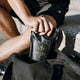 Person holding a black package labeled 'Ritua Creatine' on a stone surface.