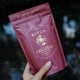 Purple package of Ritua Creatine Monohydrate held by a hand against a blurred background.