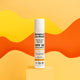 Simple as Children's Sunscreen styled on a yellow stand with and orange and yellow background.