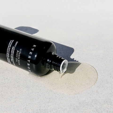 Sodashi Vitamin Rich Body Oil without cap laid down on a stone surface with oil spilling out.
