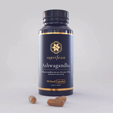 Superfeast Ashwagandha supplement bottle with capsules on a grey background.