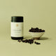 Supplement bottle labeled 'Superfeast Schisandra' with a bowl of schisandra berries on a light green background