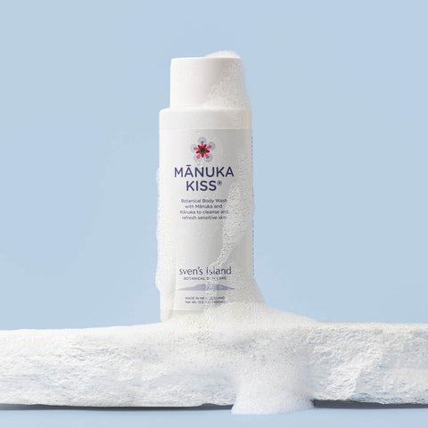 Sven's Island Manuka Kiss Body Wash on a blue background with textured slab and soap foam.
