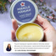 Hand holding a tin of Miracle Manuka balm with a blurred floral background and a quote with recommendation from Dr. Leela Athalye, Dermatologist.