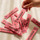 Pink creatine supplement packets on a light background.