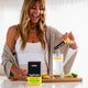 Woman adding a hydrate supplement to a glass of water with lemon slices.
